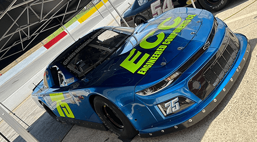 Bob Schacht's blue No. 75 race car in the pits, with Engineered Components Co. lettering on the hood