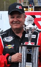 Bob Schacht in his racing jacket, holding a trophy